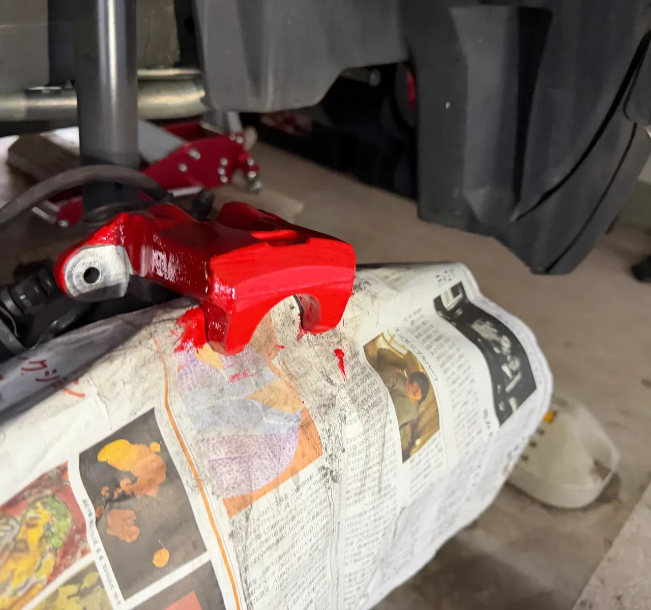 車体に取り付けた状態の赤いリアブレーキキャリパー